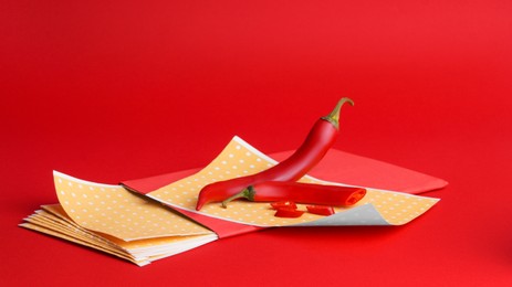 Photo of Pepper plasters and chili on red background, space for text. Alternative medicine