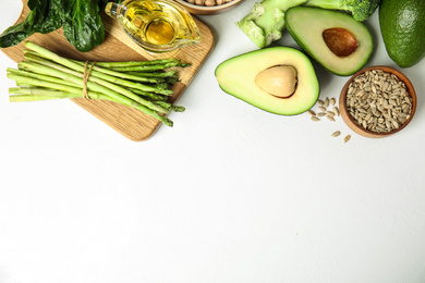 Different products rich in vitamin E on white background, flat lay