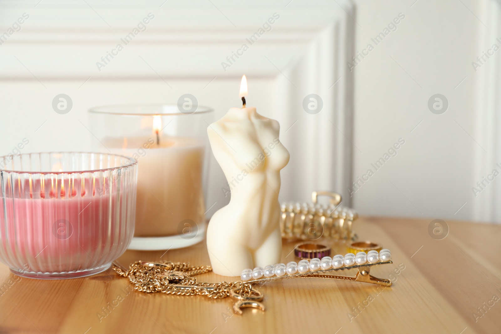 Photo of Beautiful female body shape candle on wooden table. Stylish decor