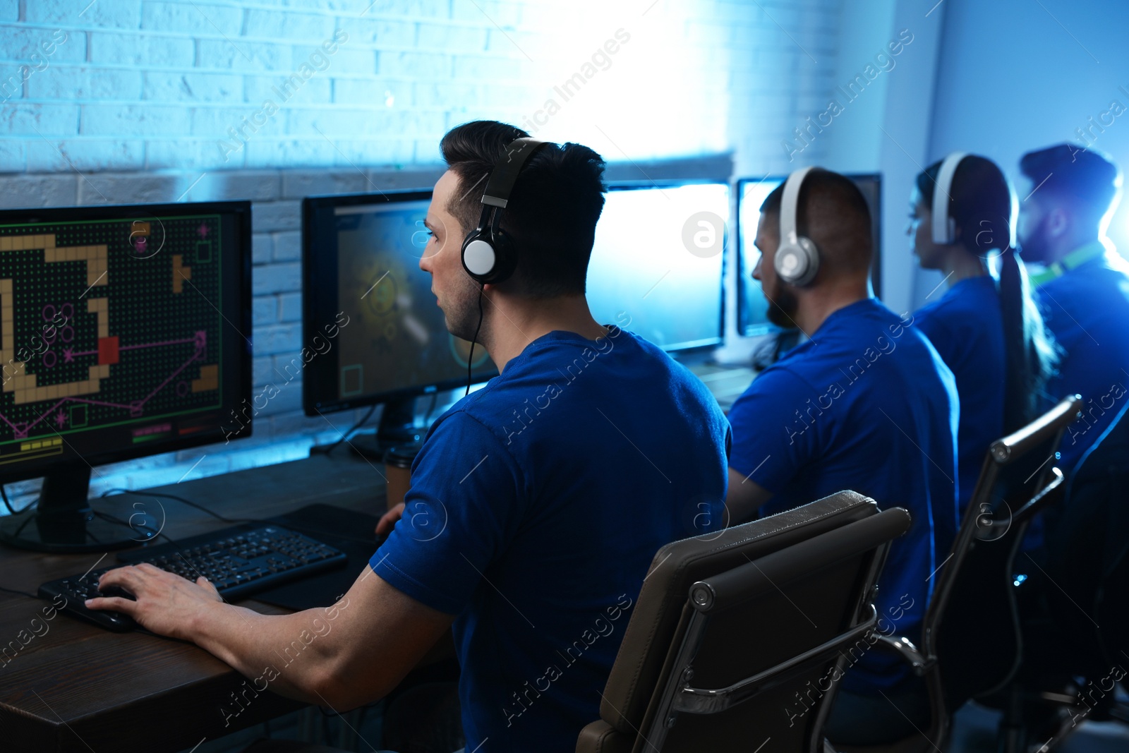 Photo of Young people playing video games on computers indoors. Esports tournament