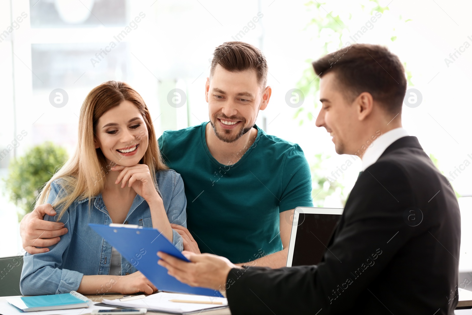 Photo of Young couple meeting with consultant in office