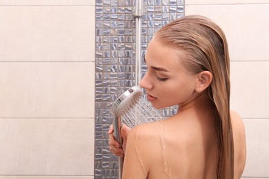 Photo of Beautiful young woman taking shower at home