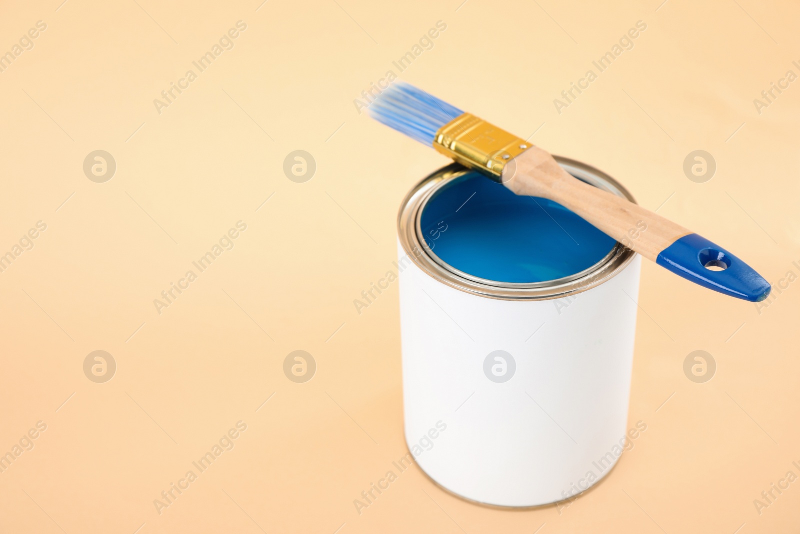 Photo of Open blank can of paint with brush on color background. Space for text
