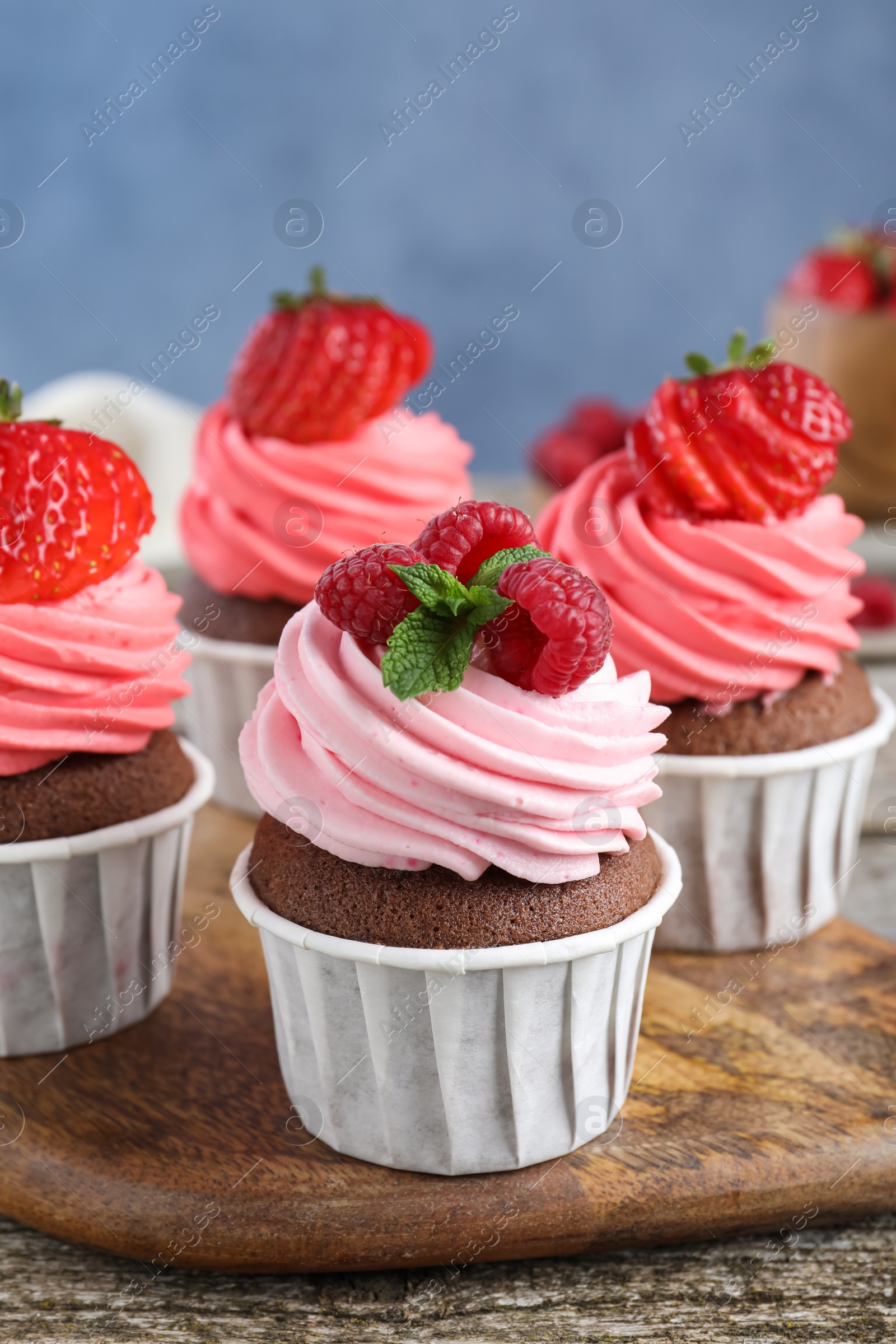 Photo of Sweet cupcakes with fresh berries on wooden table, closeup