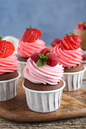 Photo of Sweet cupcakes with fresh berries on wooden table, closeup