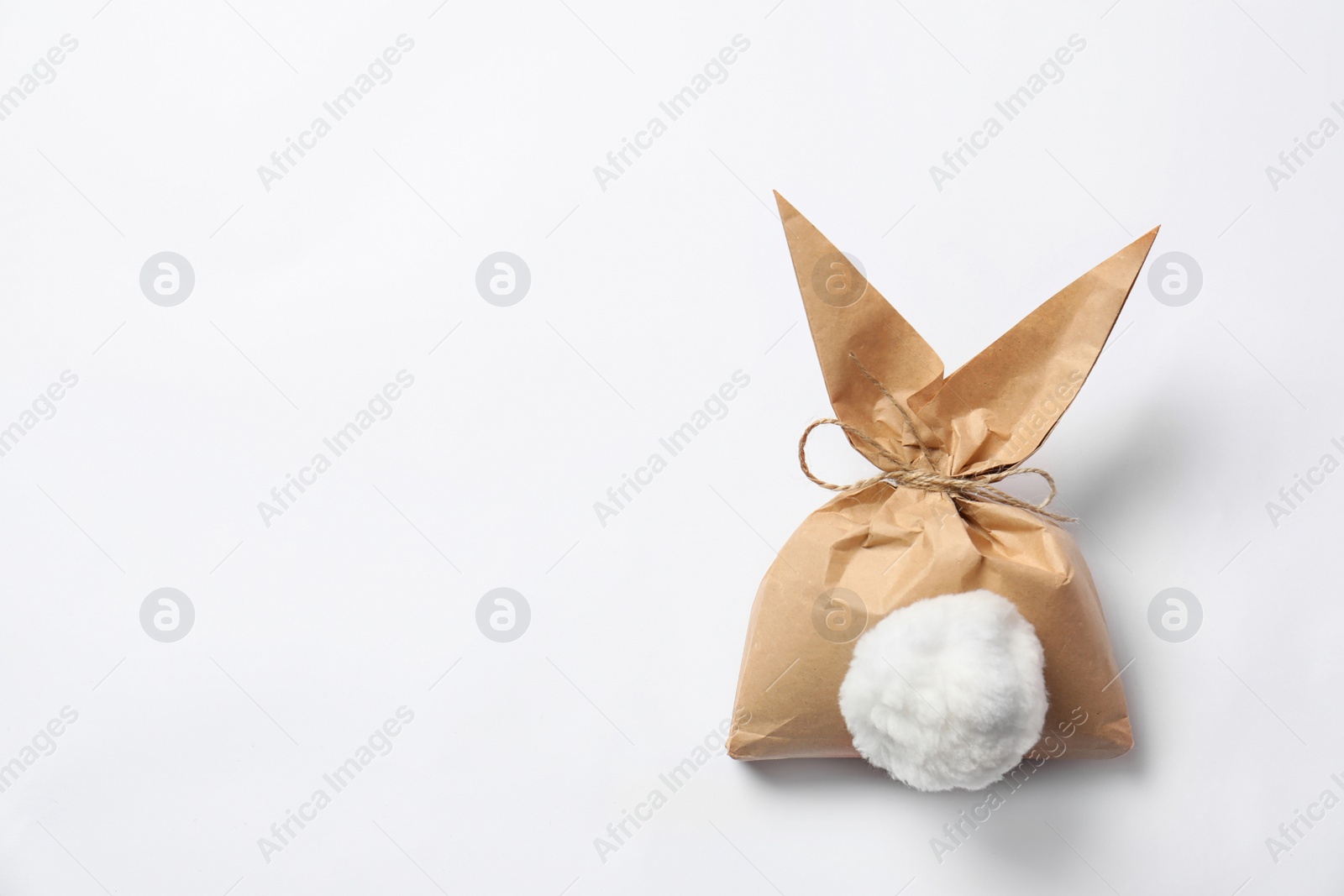 Photo of Creative Easter bunny gift bag on white background, top view