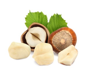 Tasty hazelnuts and green leaves on white background