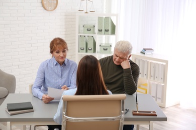 Young lawyer consulting senior couple in office