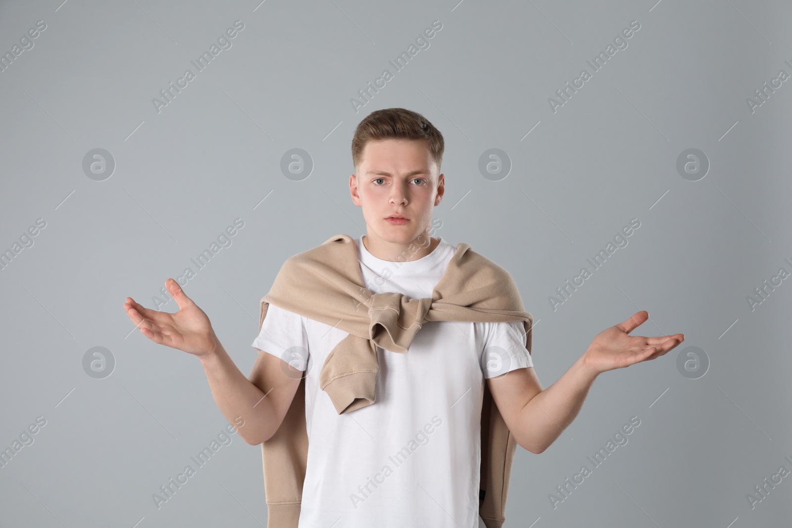 Photo of Portrait of emotional teenage boy on light grey background