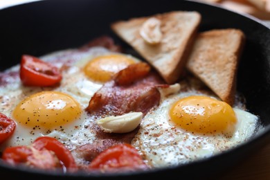 Photo of Delicious fried eggs with bacon and tomatoes in pan, closeup