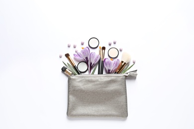 Makeup products, flowers and cosmetic bag on white background, top view