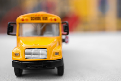 Photo of Closeup view of yellow toy school bus outdoors, space for text. Transport for students