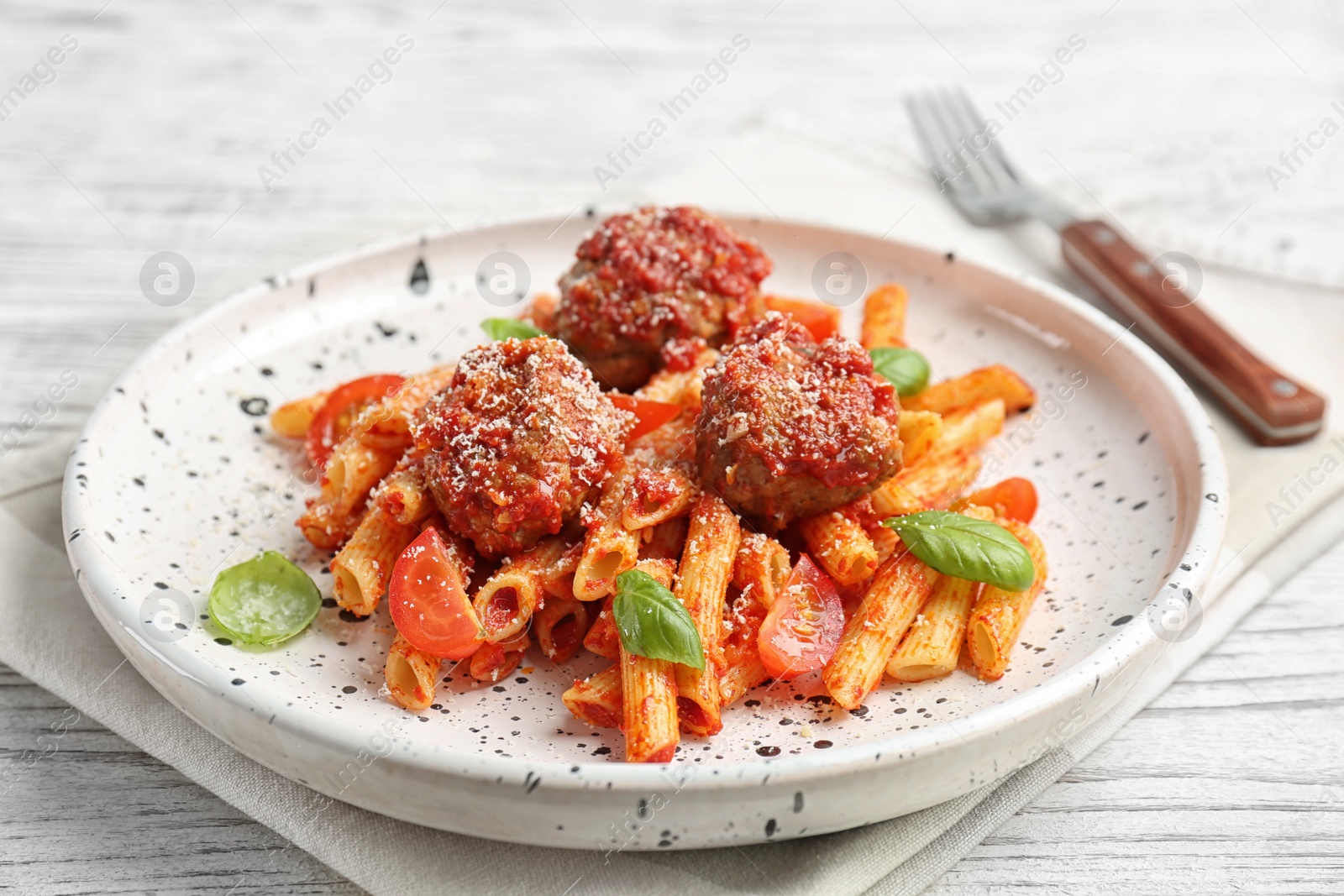 Photo of Delicious pasta with meatballs and tomato sauce on wooden background