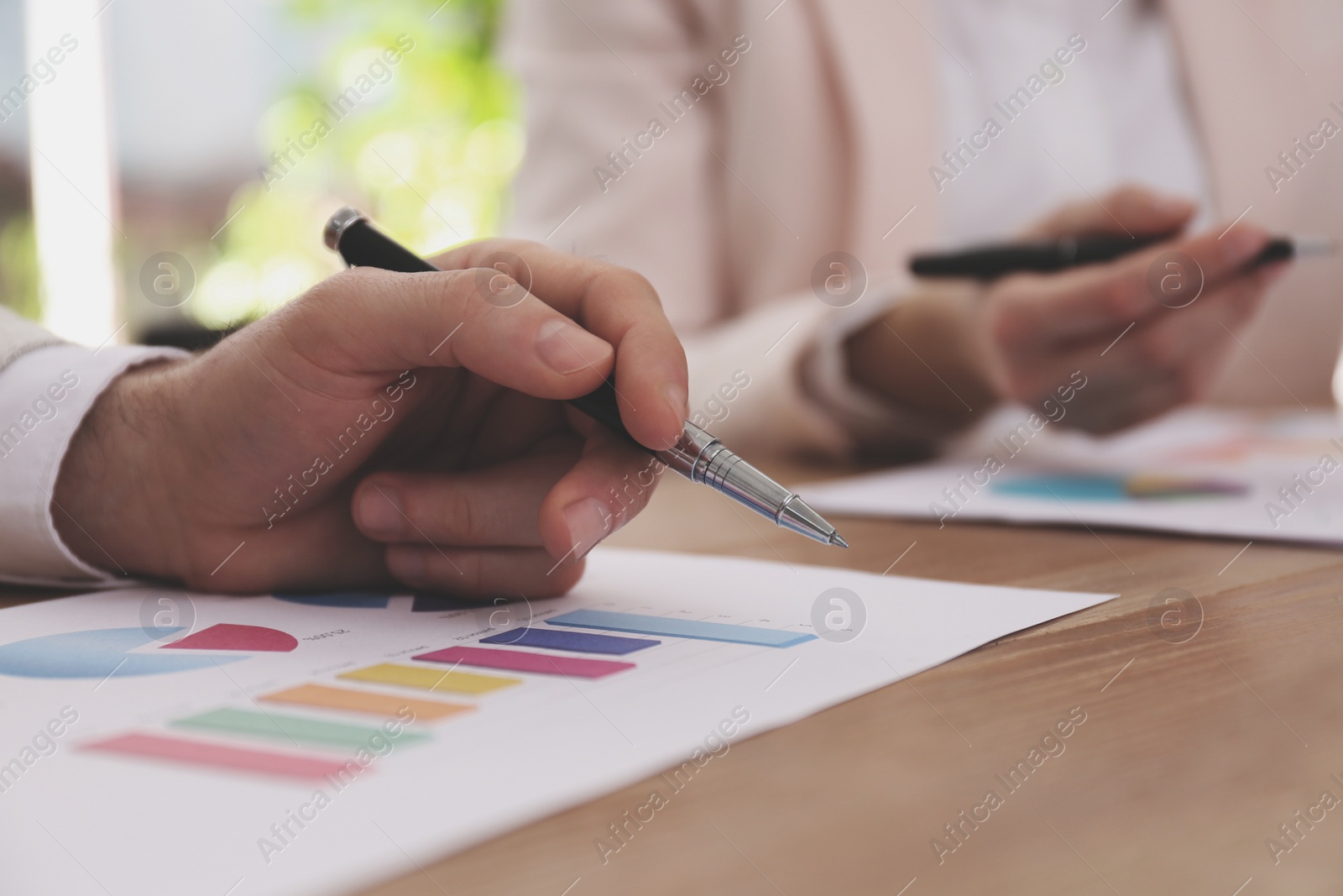 Photo of Business people working with charts and graphs at table in office, closeup. Investment analysis