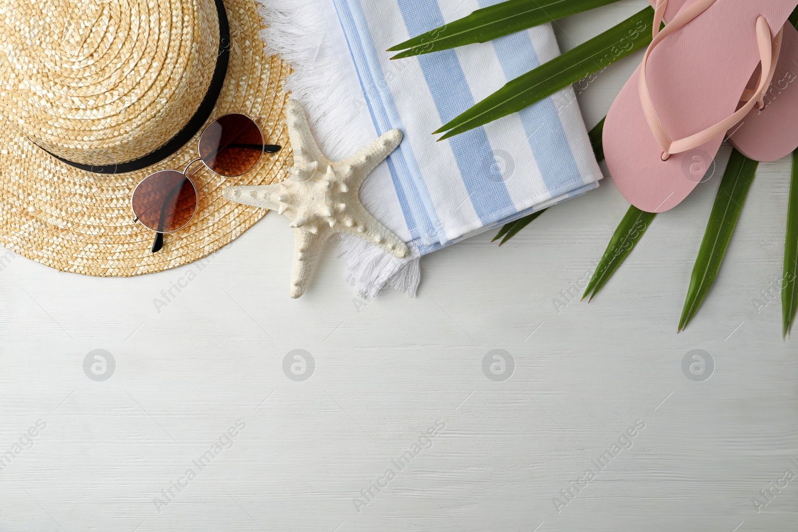 Photo of Flat lay composition with sunglasses and beach objects on white wooden background. Space for text