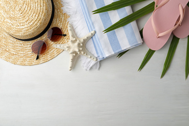 Photo of Flat lay composition with sunglasses and beach objects on white wooden background. Space for text