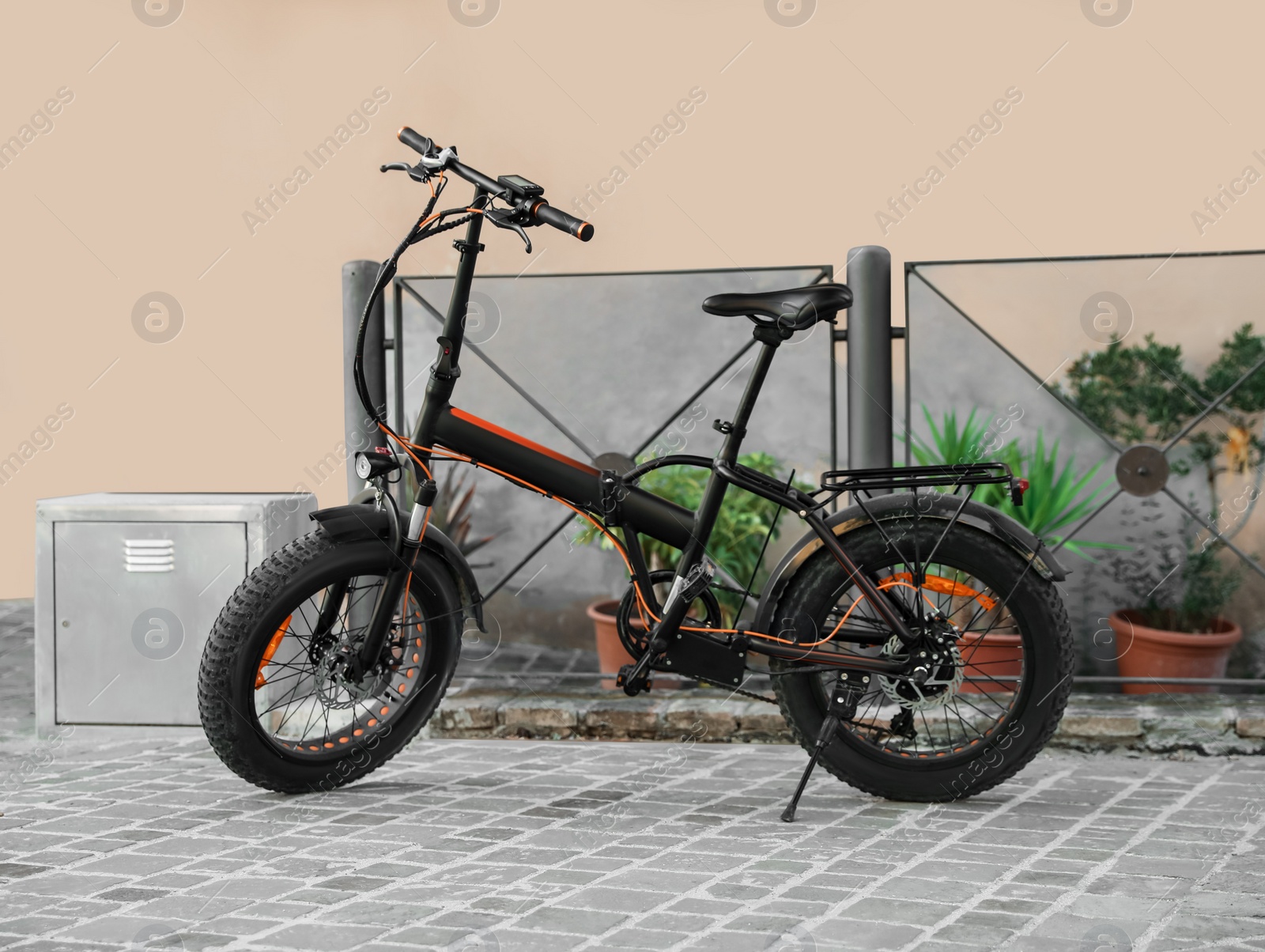 Photo of Modern electric bicycle near black metal fence outdoors