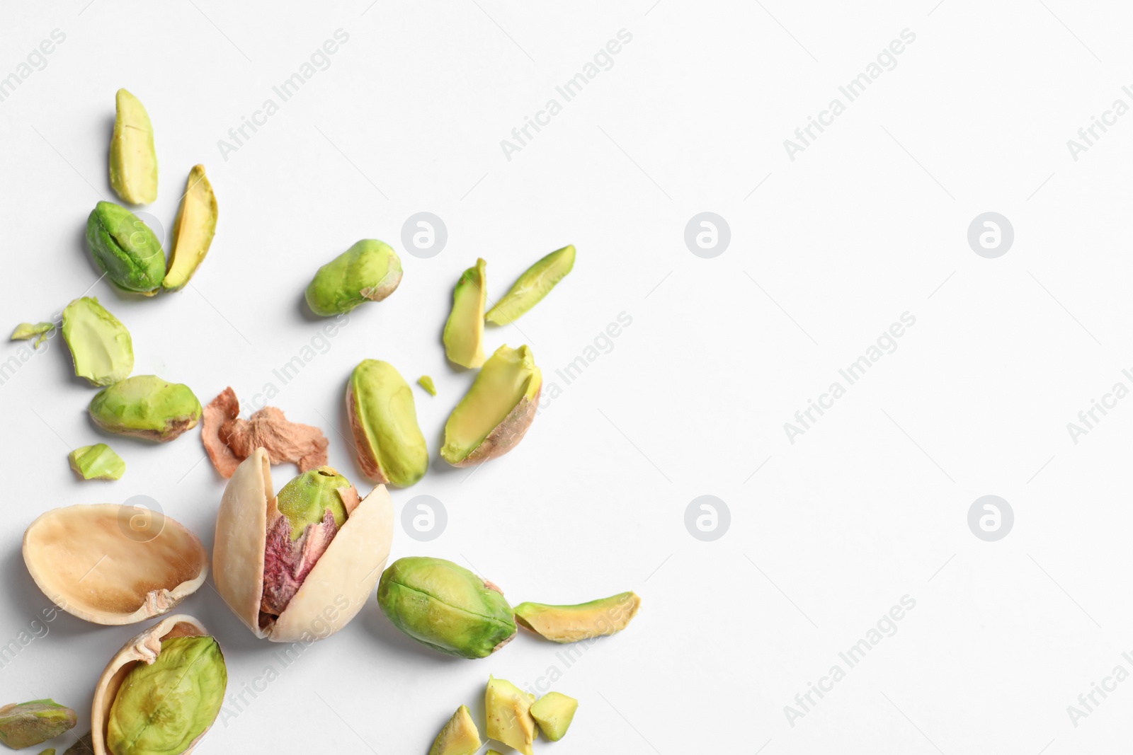 Photo of Composition with organic pistachio nuts on white background. Space for text