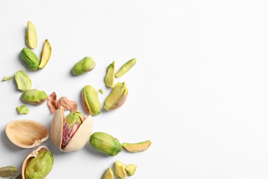 Photo of Composition with organic pistachio nuts on white background. Space for text