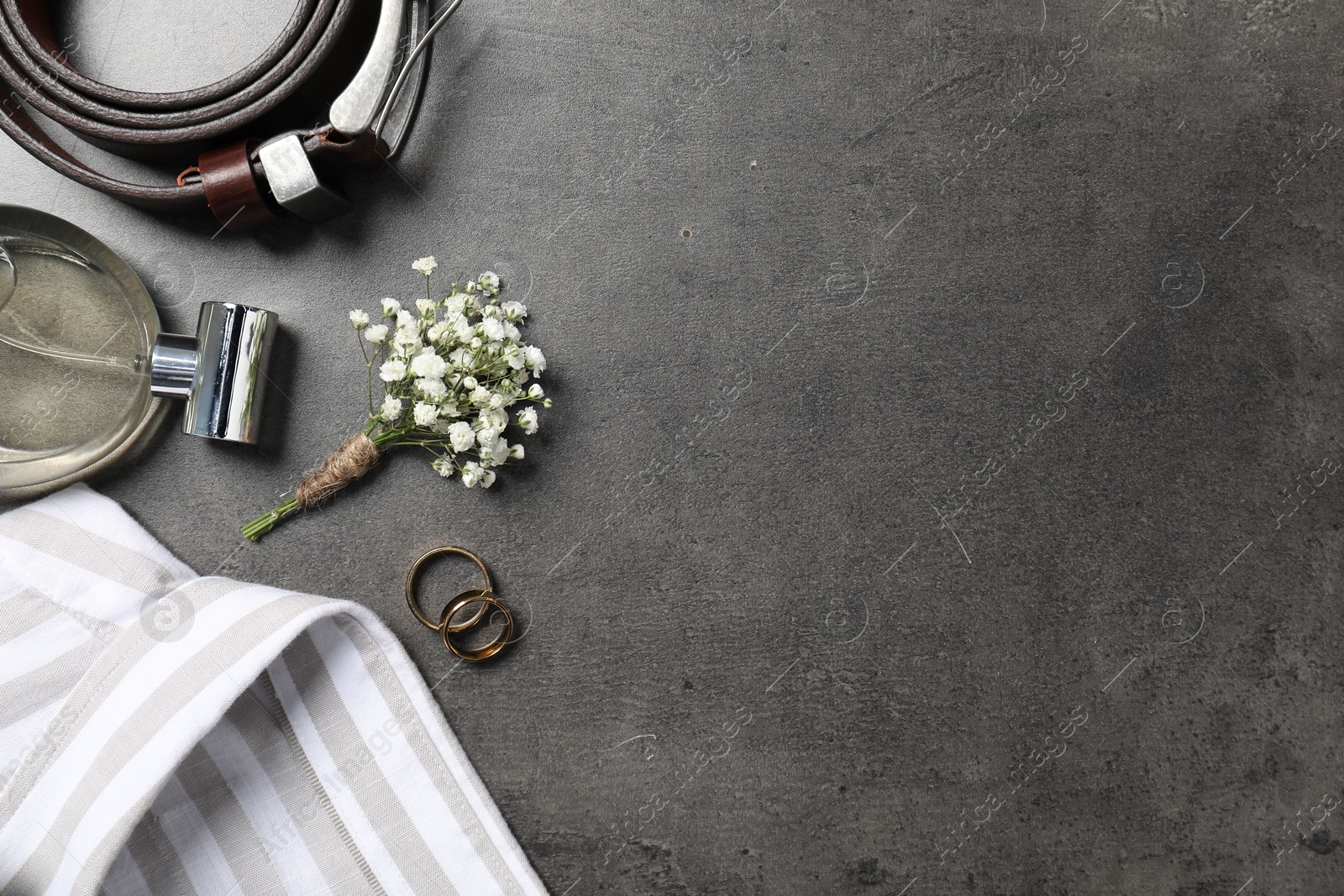 Photo of Wedding stuff. Flat lay composition with stylish boutonniere on black table, space for text