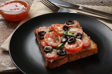 Photo of Tasty pizza toast, sauce and cutlery on wooden table, closeup