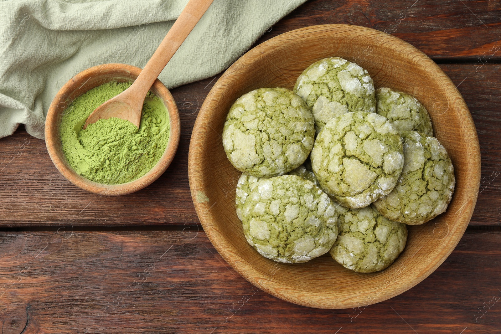 Photo of Bowl with tasty matcha cookies and powder on wooden table, flat lay. Space for text