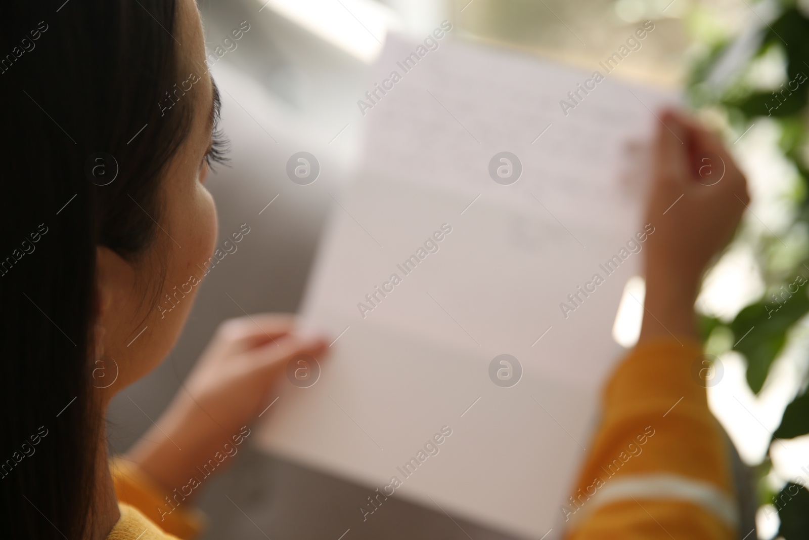 Photo of Woman reading paper letter indoors, closeup view