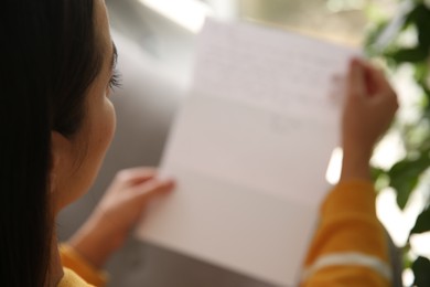 Photo of Woman reading paper letter indoors, closeup view