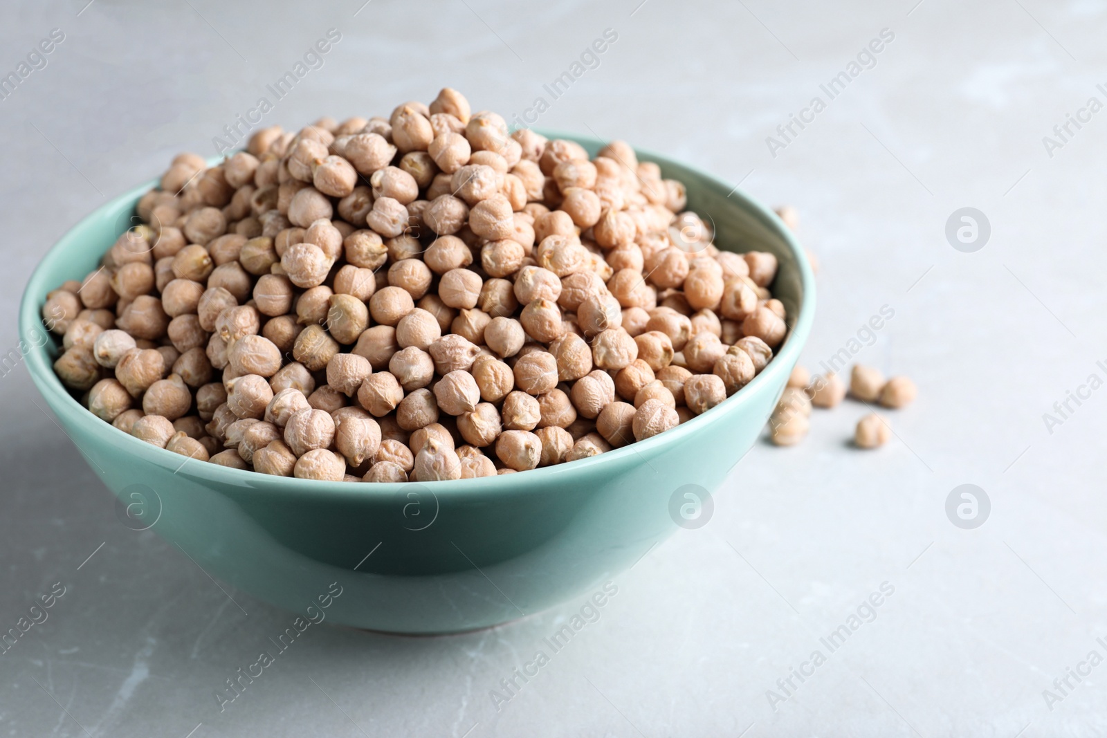 Photo of Chickpeas in bowl on light table. Natural food