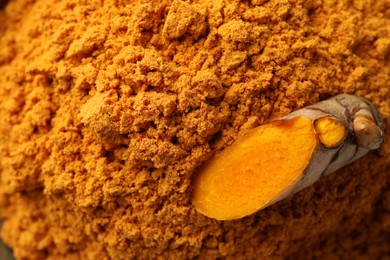 Aromatic turmeric powder and raw root as background, top view