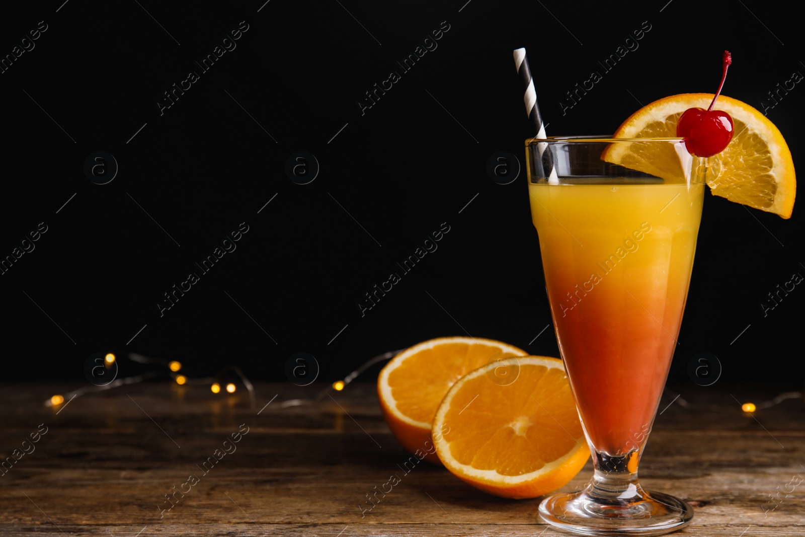 Photo of Fresh alcoholic Tequila Sunrise cocktail on wooden table. Space or text