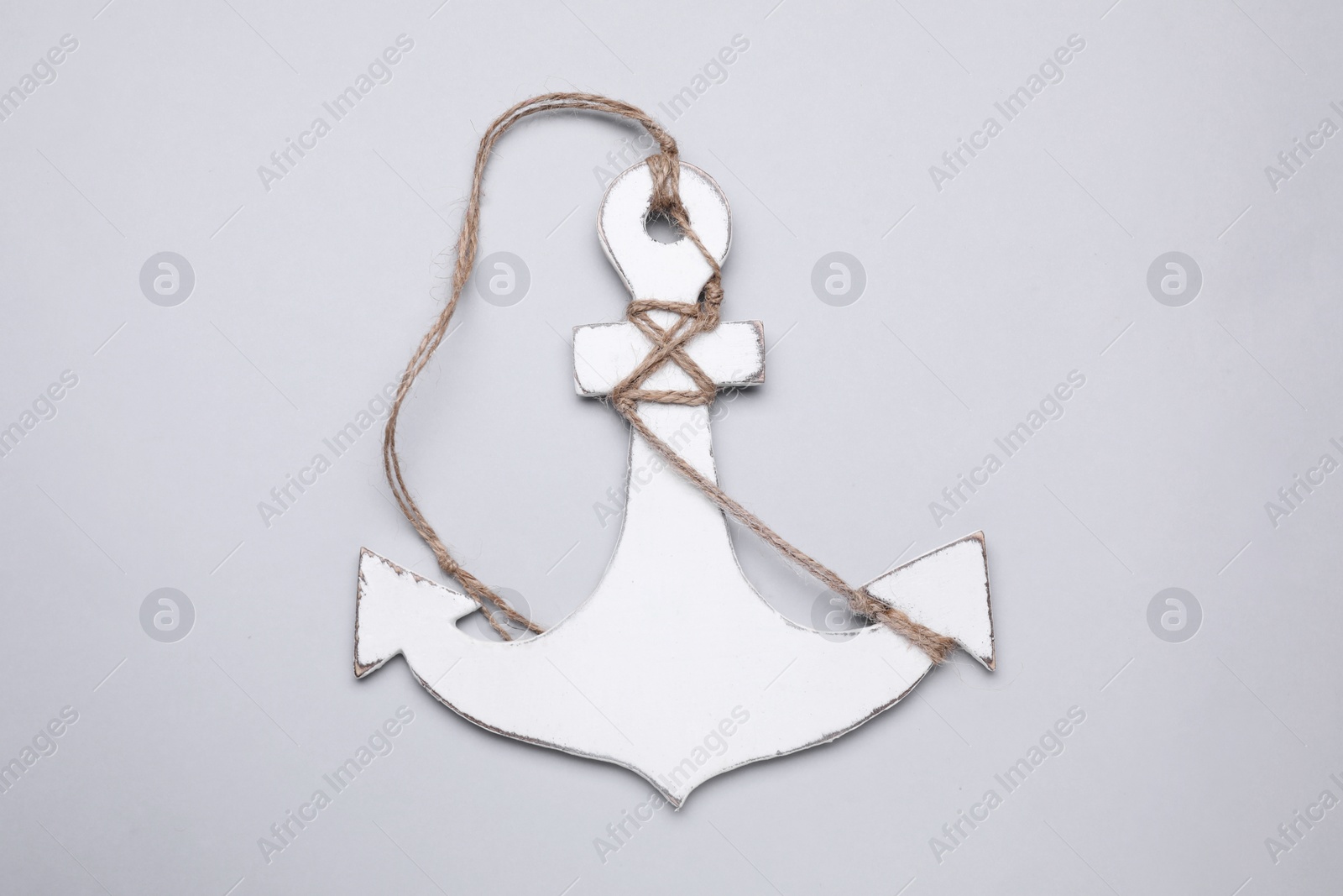 Photo of White wooden anchor figure on light background, top view