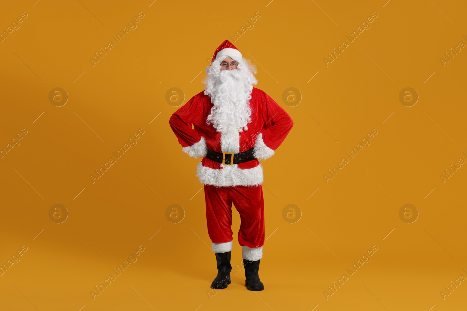 Photo of Merry Christmas. Santa Claus posing on orange background