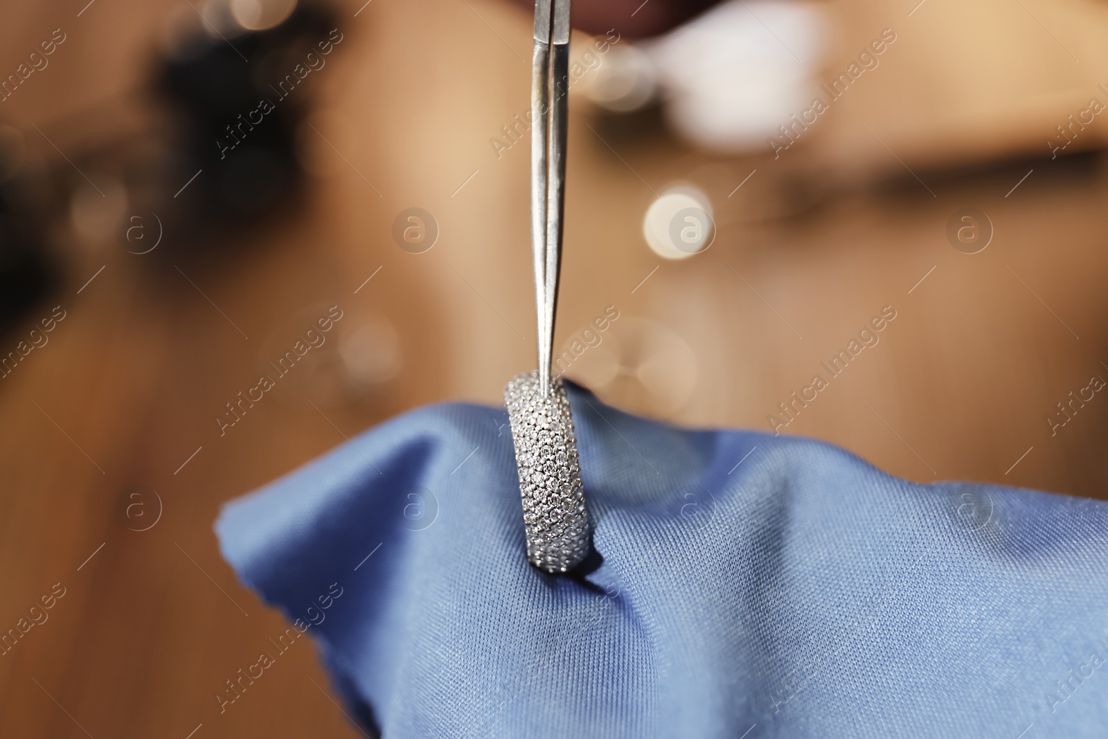 Photo of Beautiful ring with gemstones in jeweler's workshop, closeup