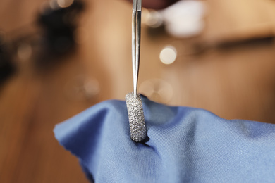 Photo of Beautiful ring with gemstones in jeweler's workshop, closeup