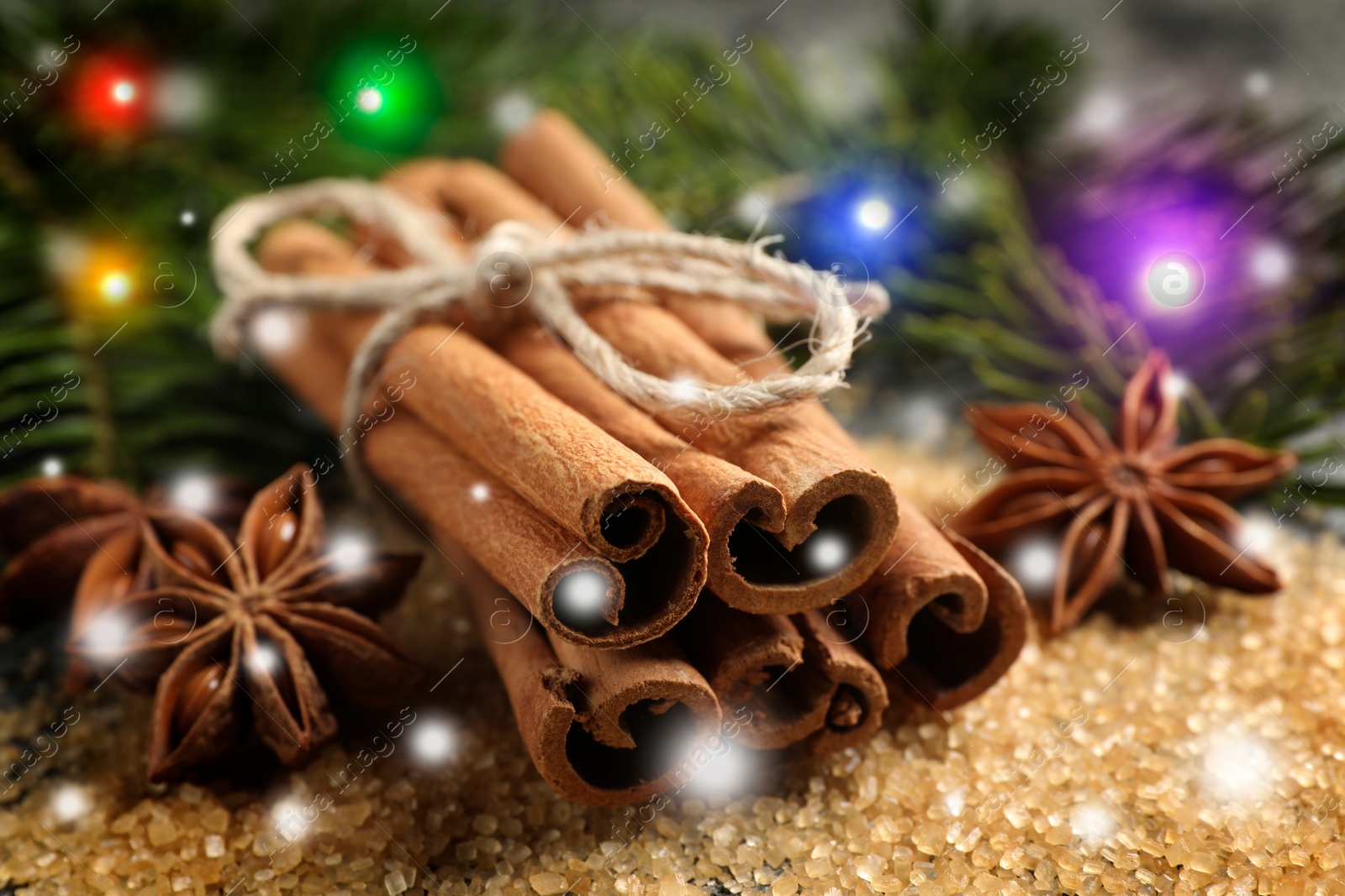 Image of Different spices and fir tree branches on brown sugar, closeup. Cinnamon, anise, brown sugar