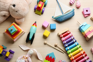 Photo of Different toys on wooden background, flat lay