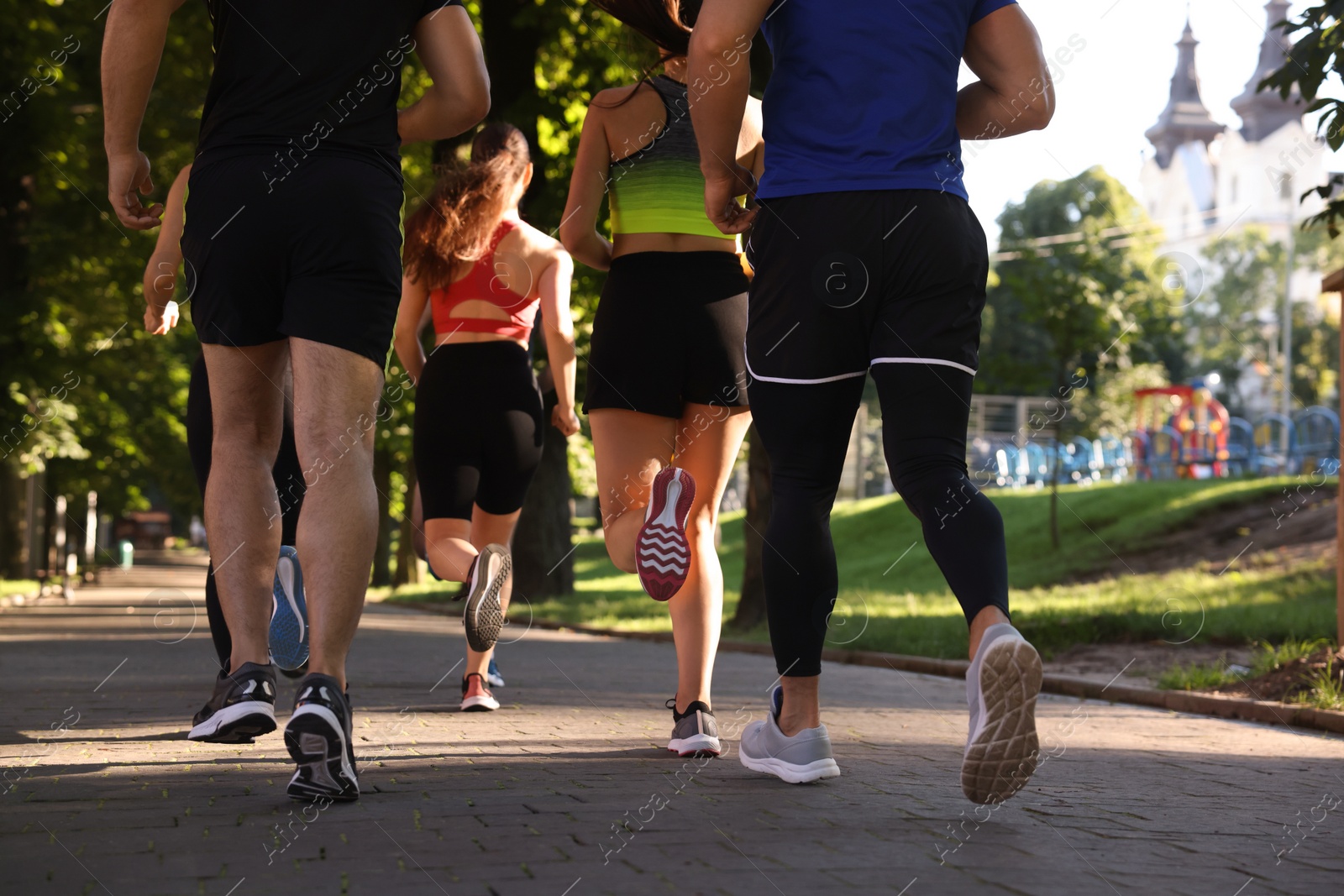 Photo of Group of people running in park, back view