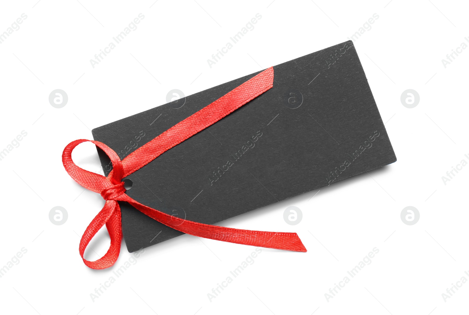 Photo of Blank black gift tag with red satin ribbon on white background, top view. Space for design