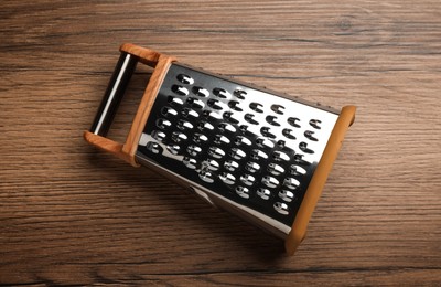 Modern grater on wooden table, top view