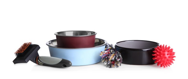 Photo of Feeding bowls, brush and dog toys on white background