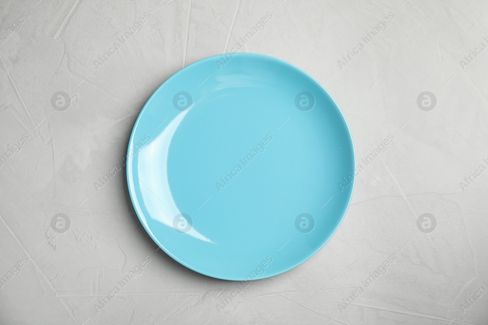 Photo of Empty  blue plate on light grey table, top view