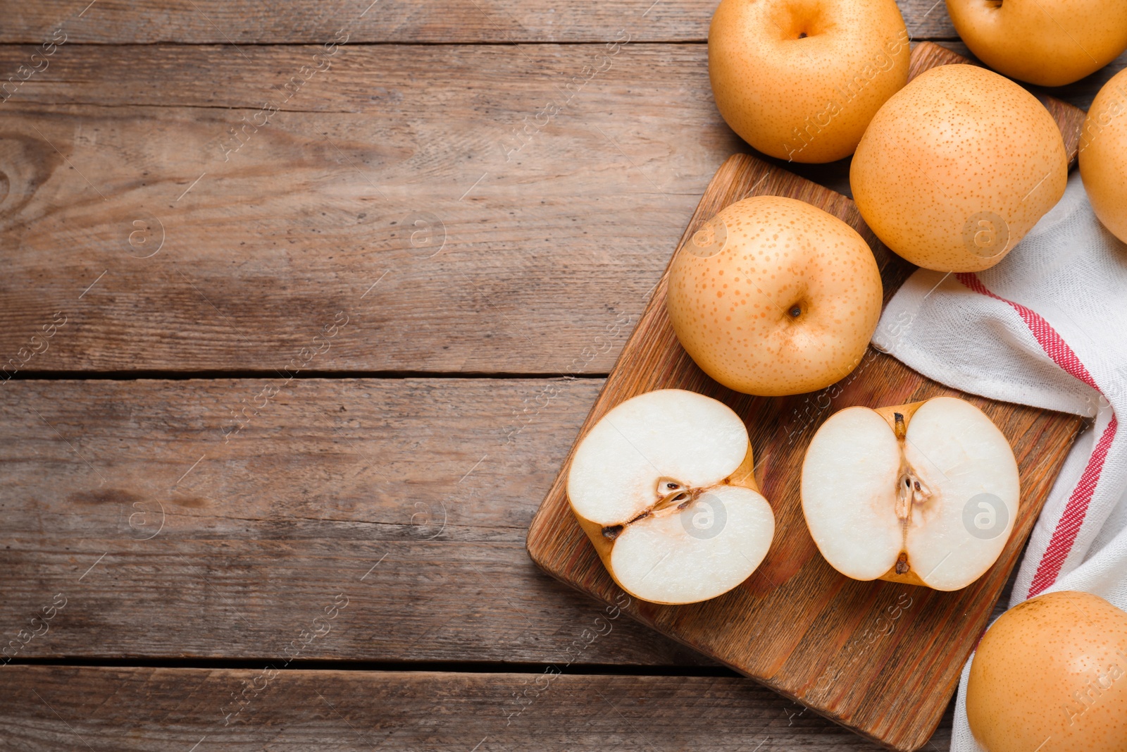 Photo of Cut and whole apple pears on wooden table, flat lay. Space for text