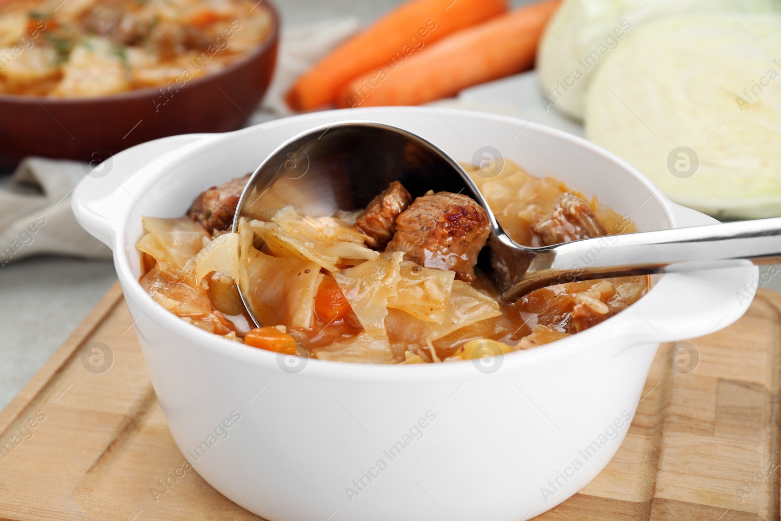 Photo of Tasty cabbage soup with meat and carrot on table, closeup