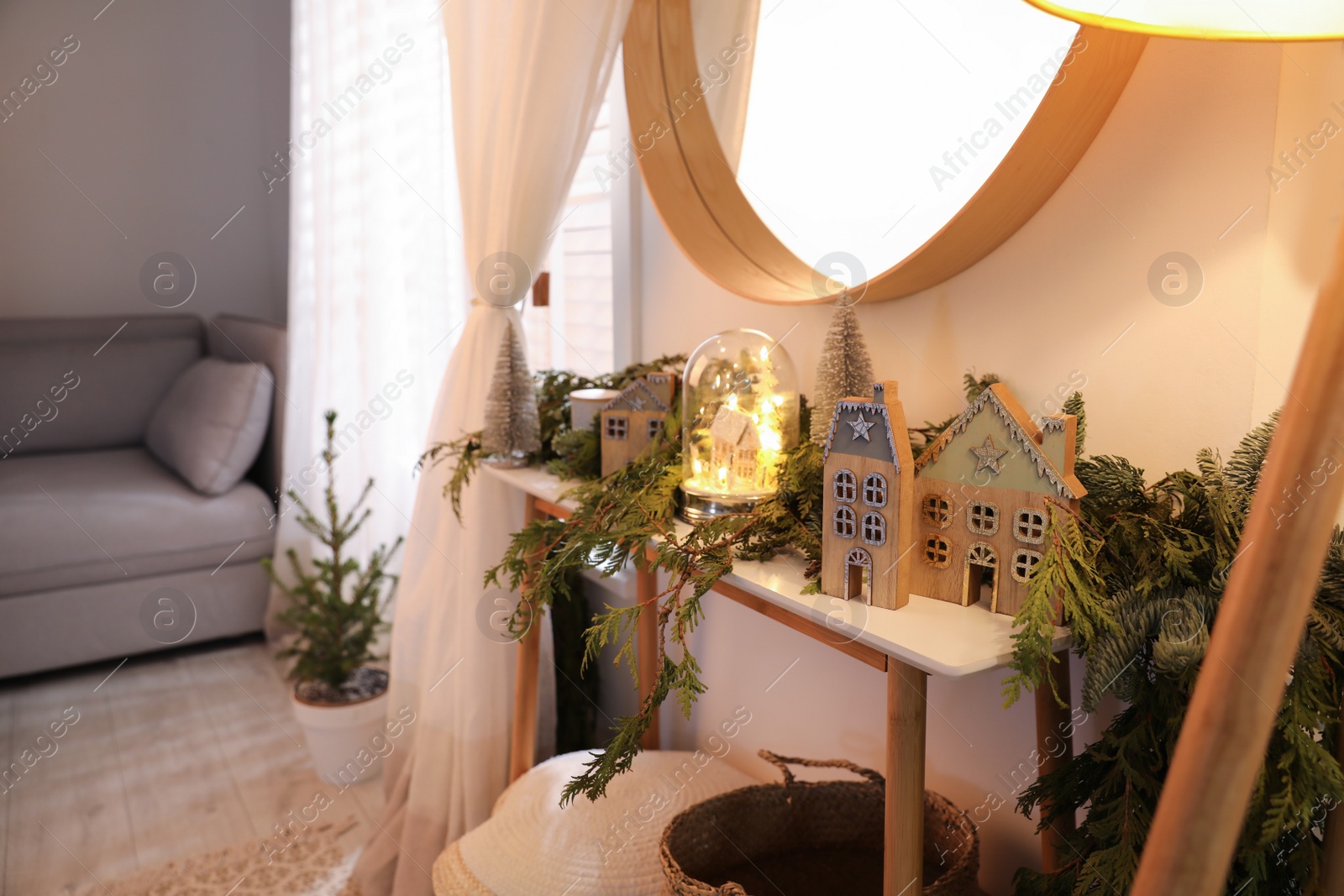 Photo of Wooden console table with Christmas decor near wall in room. Interior design