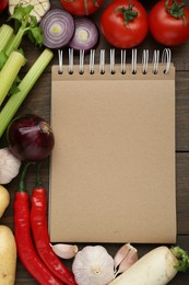 Blank recipe book and different ingredients on wooden table, flat lay. Space for text