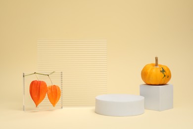 Photo of Autumn presentation for product. Geometric figures, pumpkin and physalis on beige background