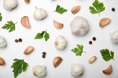 Flat lay composition with fresh garlic, parsley and allspice on white background