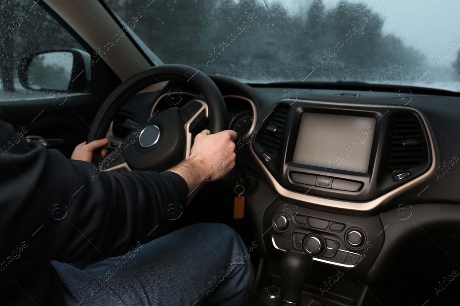 Photo of Young man driving car along winter forest, closeup