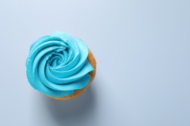 Photo of Delicious cupcake with bright cream on light background, top view. Space for text